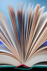 Pages of an unfolded book with a binding on a colorful background