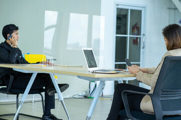 business man working apart from colleague  in the office. new normal social distancing concept.