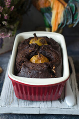 Chocolate pie with pears and nuts on a board