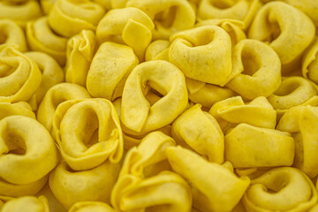  Background Italian uncooked pasta Tortellini with cheese. Traditional Italian food. Selective focus