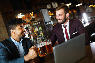 Group of happy friends drinking beer at the pub and having fun