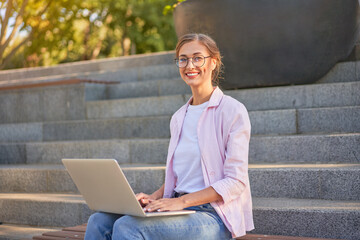 Businesswoman sitting stairs summer park using laptop Business persone working remote. Outdoor