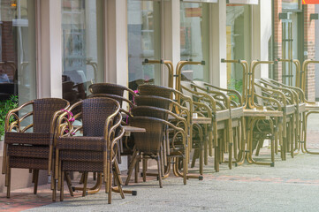 Stacked chairs and tables in front of a closed restaurant in the city center. Restrictions related to the Coronavirus Covid-19.
