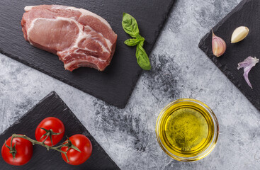 Raw pork steak with tomatoes and herbs.