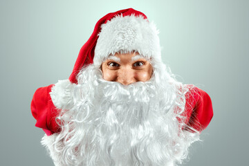 Portrait of a cheerful Santa Claus in a red suit close-up, light background. Concept for christmas eve, vacation, holiday banner, new year.