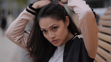 Naklejka premium Young Asian woman poses for the camera in an urban area - people photography