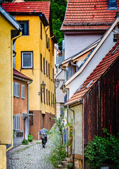 Fototapeta na wymiar Unidentified man walks up cobbled street in Esslingen-