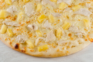 Hawaiian pizza with pineapple, chicken, cheese and sauce isolated on white wooden background. Advert for social network of restaurants, caffee. Promotion for pizzeria