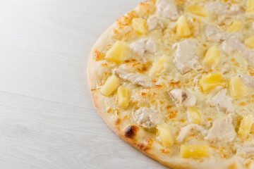 Hawaiian pizza with pineapple, chicken, cheese and sauce isolated on white wooden background. Advert for social network of restaurants, caffee. Promotion for pizzeria