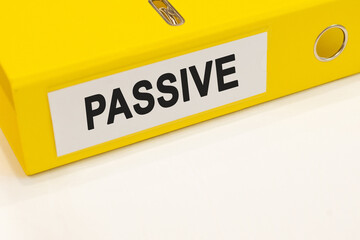 The word passive on a white background with a yellow folder. Finance concept