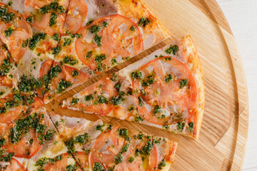 Pizza close-up on white wooden background. Food delivery for people who stay at home. Tasty fast food at quarantine coronavirus covid-19 period.