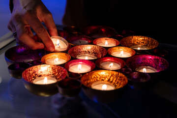 Lighting a candle on a large, colorful candlestick. Warm and cozy atmosphere.