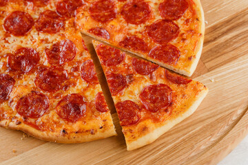 Piece of pizza close-up on the wooden desk. Advert for pezzeria caffee and restaurant. Food delivery at quarantine covid-19 concept.