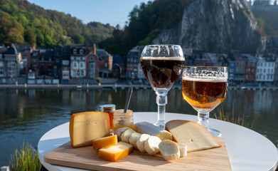 Glass of Belgian abbey beer and tasting of cheeses made with trappist beer and fine herbs with view...