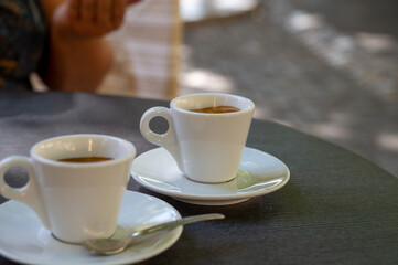 Drinking of strong black espresso coffee on outdoor terrace in cafe