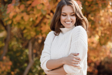 Closeup autumn portrait of a happy young woman outdoor