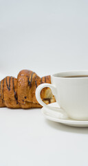Top view or flat lay of coffee cup and croissant on white background with copy space.