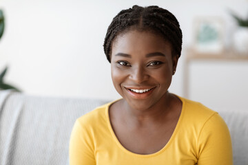 Closeup Portrait Of Attractive Young Black Woman Posing On Couch At Home