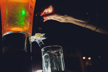 Dispenser and glasses with cold beer on table.