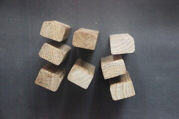 7 same and 1 different wooden blocks standing on black background. Leadership and team abstract business concept