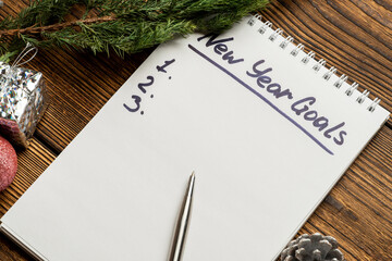 new year goals inscription in notebook with fir, spruce branches and Christmas tree toys
