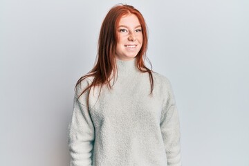 Obraz premium Young red head girl wearing casual winter sweater looking to side, relax profile pose with natural face and confident smile.