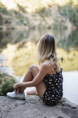 blonde woman looking at water in a lake