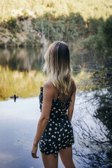 blonde woman looking at water in a lake