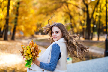 Blonde teenage girl posing in autumn park