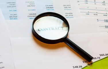 Magnifier on contract paper with financial statements. Home business diagram.
