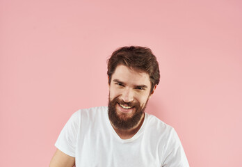 Obraz premium Portrait of a man in a white T-shirt on a pink background close-up model