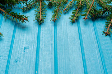 Fir, spruce branches on blue wooden background