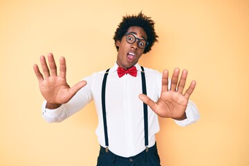 Handsome african american man with afro hair wearing hipster elegant look afraid and terrified with...