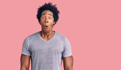 Handsome african american man with afro hair wearing casual clothes afraid and shocked with surprise expression, fear and excited face.