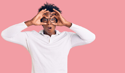 Handsome african american man with afro hair wearing casual clothes and glasses trying to open eyes...