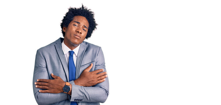 Handsome african american man with afro hair wearing business jacket shaking and freezing for winter cold with sad and shock expression on face