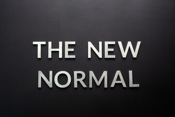 words the new normal on black surface in flat lay perspective