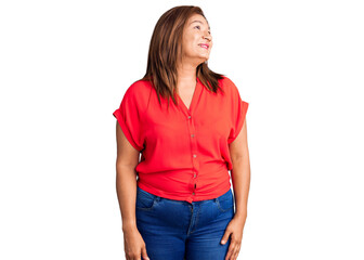 Middle age latin woman wearing casual clothes looking away to side with smile on face, natural expression. laughing confident.