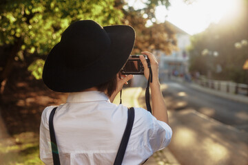 The girl in the black hat shooting in an old european town.