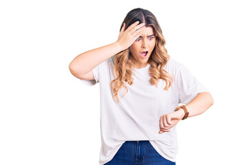 Young caucasian woman wearing casual clothes looking at the watch time worried, afraid of getting...