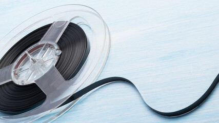 old cassette with magnetic tape on blue table background