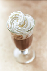 Coffee with whipped cream on bright stone background. Soft focus. Close up.