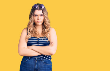 Young caucasian woman wearing casual clothes and sunglasses skeptic and nervous, disapproving...