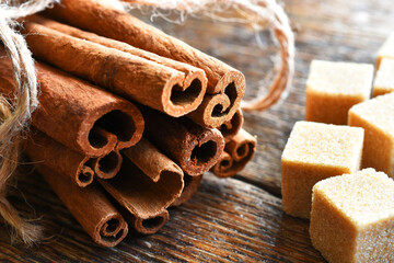 Obraz na płótnie Canvas A close up image of fresh cinnamon sticks and brown sugar cubes. 