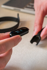 charging smart band on laptop. Fitness tracker.