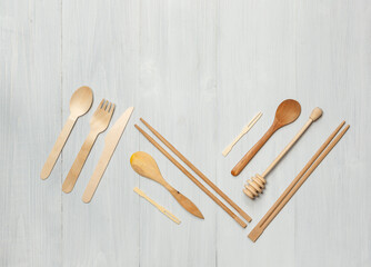 Wooden Cutlery and kitchen utensils on light boards. Top view, horizontally with space