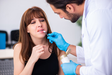 Young woman visiting male doctor dermatologist