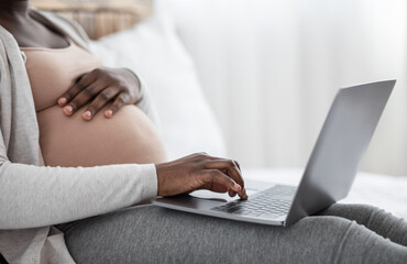 Naklejka premium Pregnancy And Technology. Unrecognizable Black Pregnant Lady Using Laptop At Home, Cropped