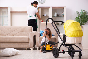 Young male contractor cleaning the house with his small daughter