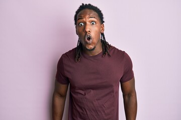 African american man with braids wearing casual clothes scared and amazed with open mouth for...